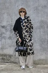Tapado largo de poliéster con estampado animal print tipo leopardo, solapas amplias y cierre frontal cruzado con botones.