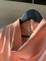 Blusa sin mangas de satén color rosa blush, con escote drapeado y caída fluida.