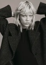 Abrigo largo estilo oversize con diseño de cuadros, cuello con solapa de muesca, cierre delantero con botones y bolsillos laterales.