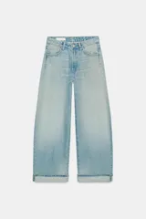Jeans baggy de tiro medio color celeste, con diseño de pernera ancha, bajo con vuelta y cierre frontal con cremallera y botón metálico.