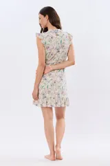 Vestido corto de lino estampado con diseño floral en tonos lila y verde, sin mangas, con cuello mao, botones frontales, volados en los hombros y detalle de lazo en la cintura.