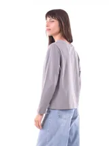 Remera de manga larga color azul, con cuello redondo y un estampado central de flores en tonos pastel sobre un recuadro gris claro.