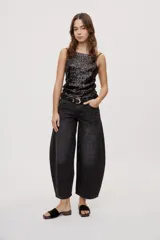 Jean de tiro medio y corte barrel con pierna amplia y ligeramente curva, estilo de cinco bolsillos en denim negro lavado.
