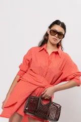Camisa larga amplia color coral con patrón a cuadros, cuello camisero, cierre frontal con botones y grandes bolsillos en el pecho.