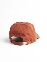 Gorro con visera color beige, con logo bordado de una montaña en el frente.