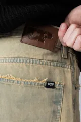 Jean de corte mom oversize, color negro lavado, con diseño de cinco bolsillos y cierre frontal con botón y cremallera.