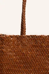 Cartera tote de cuero vacuno trenzado a mano, color bordó, de diseño espacioso con asas firmes.