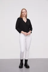 Pantalon jean de corte skinny y calce medio, color blanco, con bolsillos laterales y traseros.