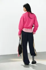Sudadera fucsia con efecto lavado, confeccionada en mezcla de algodón. Cuenta con cuello redondo con una pequeña abertura frontal con botones, manga larga caída y puños y dobladillo en rib.