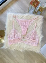 Conjunto de lencería compuesto por un bralette de encaje con cierre frontal y una tanga colaless a juego, ambos confeccionados en encaje suave y elastizado.