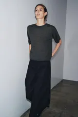 Jersey de punto liso color gris oscuro, con cuello redondo y mangas cortas amplias.