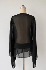 Vestido corto negro de microtul transparente, con escote pronunciado en V y mangas largas amplias tipo campana.