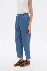 Pantalón de corte recto y tiro medio, confeccionado en lyocell color azul, con cintura elástica y bolsillos laterales.