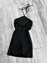 Vestido corto negro de satén con escote halter y espalda descubierta.