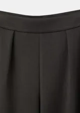 Pantalón de corte ancho, color marrón oscuro, de tiro medio y diseño fluido.