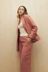 Pantalón de tiro alto color ladrillo, de corte ancho y con cinturón de la misma tela.