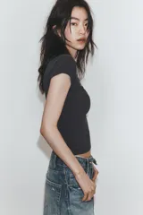 Camiseta slim fit color gris oscuro, con cuello redondo y manga sisa caída. Presenta un texto blanco en el delantero que dice "Main character Role".