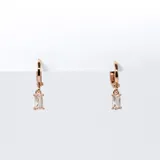 Par de aros tipo argolla color oro rosa con dije colgante rectangular de cristal transparente.