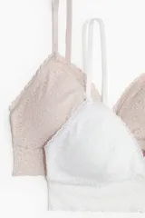 Pack de dos soutiens de encaje, uno color beige y otro blanco, con breteles ajustables y copas acolchadas con relleno extraíble.