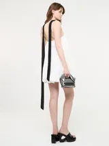 Vestido corto negro, estilo globo o balloon, con escote corazón pronunciado. Se lleva sobre una remera blanca de manga corta.