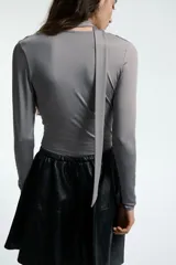 Remera de manga larga en punto elástico, color gris, con cuello drapeado y tiras anchas integradas.
