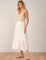 Vestido midi combinado de Elan, con torso de punto beige de escote en V y breteles anchos, y falda escalonada blanca de largo midi.