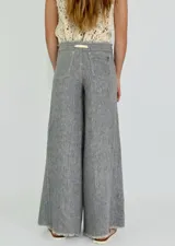 Pantalón de lino color ladrillo, de corte palazzo y tiro alto, con bolsillos laterales y cordón ajustable en la cintura.