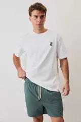 Short de baño color gris oscuro, con cintura elástica ajustable mediante cordones blancos y un pequeño parche decorativo en el borde inferior.