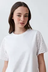 Remera fucsia de manga corta con detalle de broderie en las mangas.