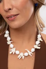 Collar corto de diseño artesanal compuesto por cuentas ovaladas blancas y bastones naturales de nácar intercalados.