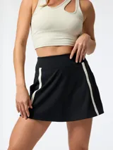 Skort deportivo negro con short interior integrado, cintura alta y franjas verticales blancas en los laterales. Confeccionado con tecnología Aloe Vera.