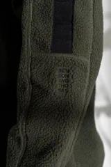 Sweater de polar negro con medio cierre y detalles en azul en mangas y cuello.