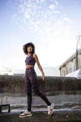 Calza larga negra con estampado abstracto en tonos rosa y rojo.