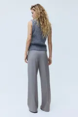 Pantalón sastrero gris de tiro alto, con cierre y corchete ocultos, piernas rectas con raya marcada al frente y en la espalda, y bolsillos laterales al bies.