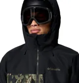 Campera de esquí Columbia con tecnología Omni-Tech impermeable y transpirable. Presenta un diseño bicolor con la parte superior en negro y la parte inferior con estampado camuflado. Incluye capucha ajustable compatible con casco, cierre frontal, múltiples bolsillos funcionales y ventilación en las axilas.
