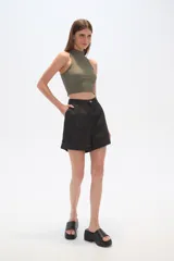 Short de jean de tiro alto con corte holgado y ruedo con dobladillo. Presenta cierre frontal con botón y bolsillos laterales.