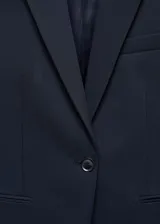 Blazer de corte entallado y diseño recto, con solapas con muesca, hombros estructurados y cierre frontal de un botón. Cuenta con dos bolsillos de ribete delanteros, abertura posterior y forro interior.