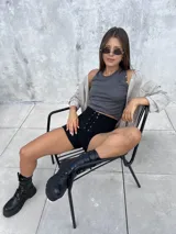 Short de tiro alto confeccionado en tela tipo gamuza scuba, con cierre frontal mediante cordones y ojalillos metálicos. Presenta un diseño ajustado y elástico que se adapta a la silueta.