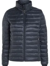 Campera acolchada azul marino de poliéster reciclado, con capucha y cierre de cremallera. Tiene dos bolsillos laterales con cremallera, es repelente al agua y presenta el logo de Tommy Hilfiger bordado en el pecho.