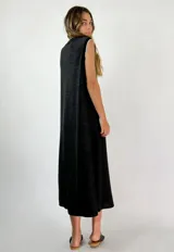 Vestido midi negro sin mangas, con escote en V y ribete blanco en el cuello y las sisas.