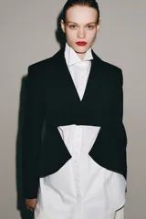 Blazer asimétrica de Zara Woman Collection, confeccionada con mezcla de lana. Presenta cuello solapa, manga larga con botones, cierre frontal con un botón y bajo asimétrico con abertura. Incluye forro interior a tono.