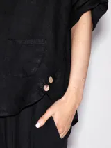 Remera negra de lino con cuello redondo y bolsillo en el pecho.
