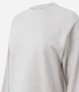 Blusa básica de manga larga con cuello redondo y puños ajustados, confeccionada en tejido de algodón y poliéster. Presenta un corte regular anatómico y diseño liso sin estampas.