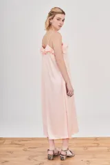 Vestido midi de estilo lencero en color rosado, confeccionado en tejido jacquard con sutil estampado animal print. Presenta escote en V con detalle de volados, breteles finos y corte recto con caída fluida.