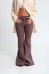 Jean oxford color marrón con recortes y costuras en contraste color rojo. Confeccionado en algodón con elastano.