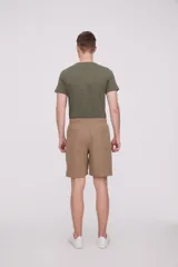 Bermuda de corte recto y diseño minimalista, confeccionada en tejido técnico de poliéster. Presenta cintura elástica con cierre de botón frontal, bolsillos laterales y un bolsillo pequeño adicional en el lateral izquierdo.