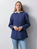 Campera impermeable de corte recto con cierre frontal completo y capucha integrada con forro a rayas. Presenta bolsillos laterales y detalles metálicos plateados.