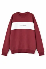 Buzo de cuello redondo en color bordó, con una franja horizontal blanca en el pecho que incluye el logo de la marca estampado en el centro. Presenta puños y ruedo acanalados.