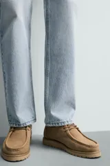 Zapato de cordones para hombre confeccionado en piel con acabado de serraje en color beige. Presenta un detalle de bordón en el empeine, horma redonda y una suela track a tono.