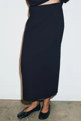 Falda midi de punto con tiro alto y cintura elástica, de corte ajustado y diseño minimalista.
